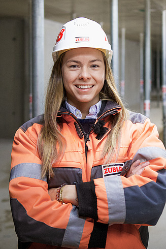 Frau in Arbeitsschutzkleidung lächelt in die Kamera