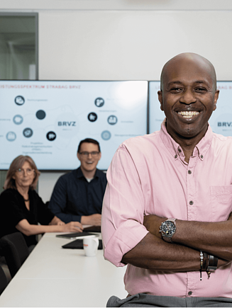 Vier Personen sitzen im Büro um einen Tisch und führen ein Gespräch.