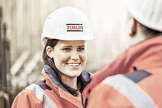 Foto medarbetare med bygghjälm tittar på medarbetare med bygghjälm